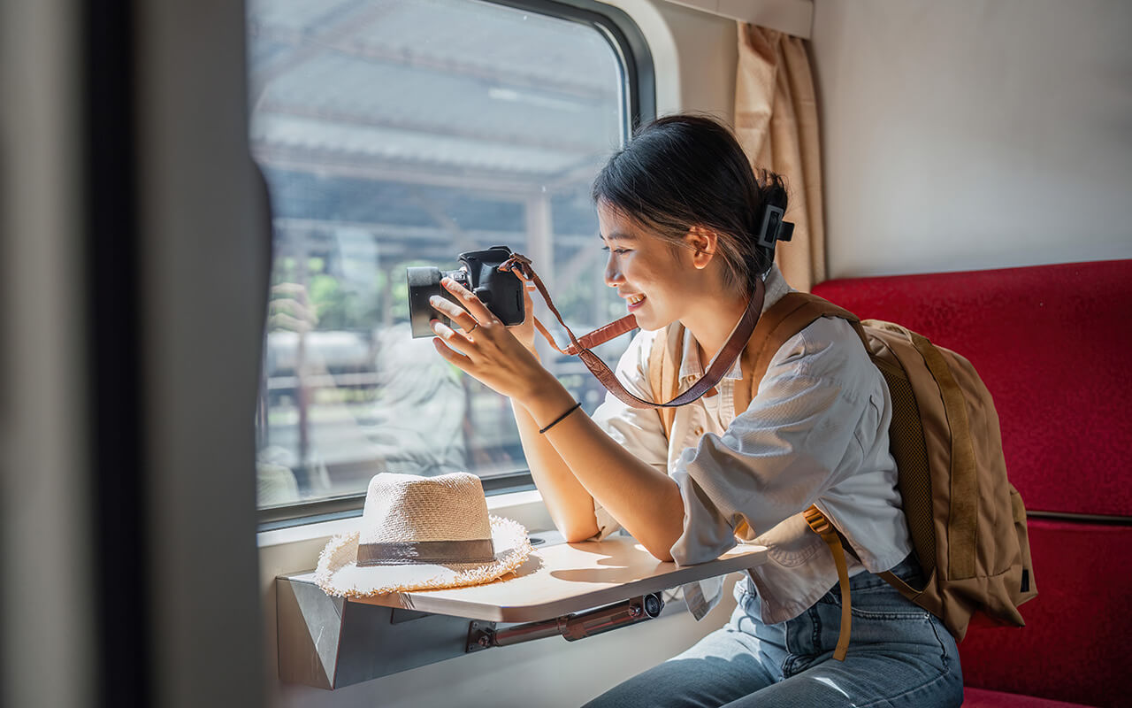 Woman taking photos on a camera in a train