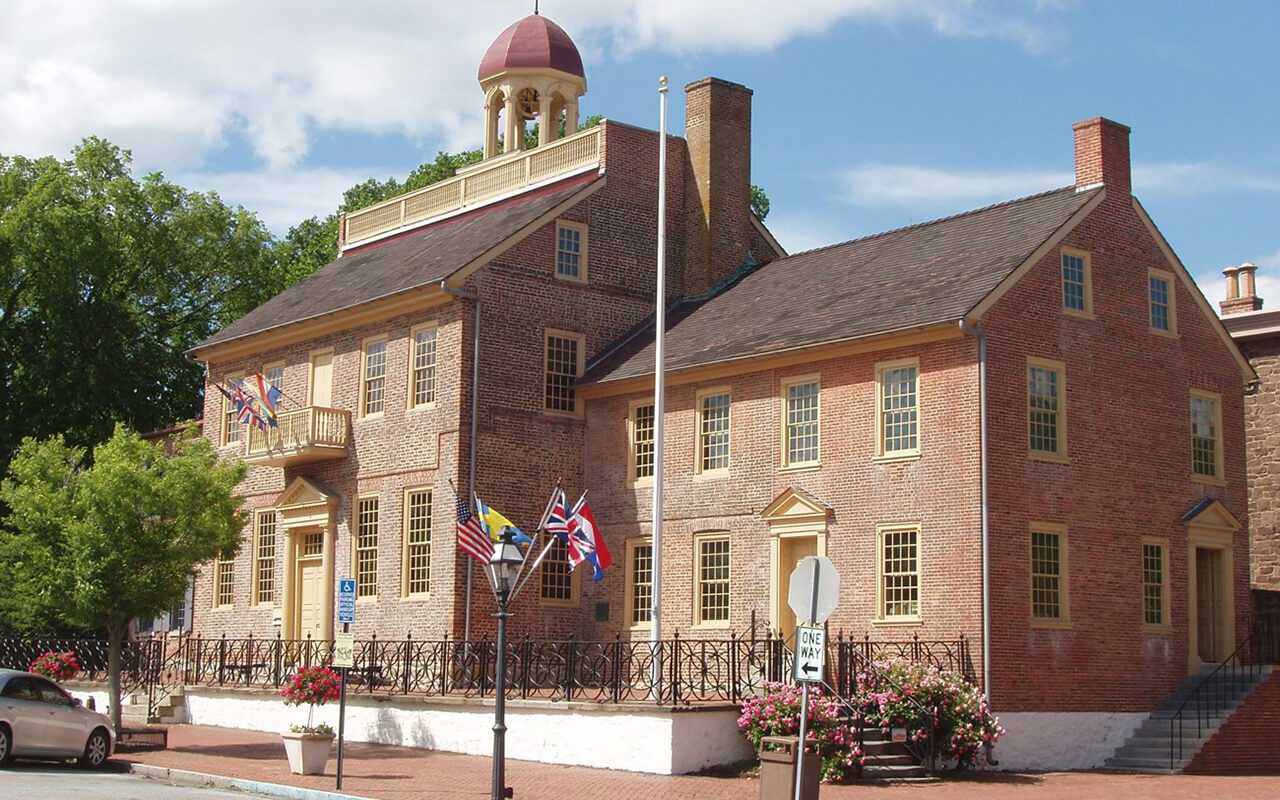 The front and right side of the New Castle Court House are shown on a bright sunny day.