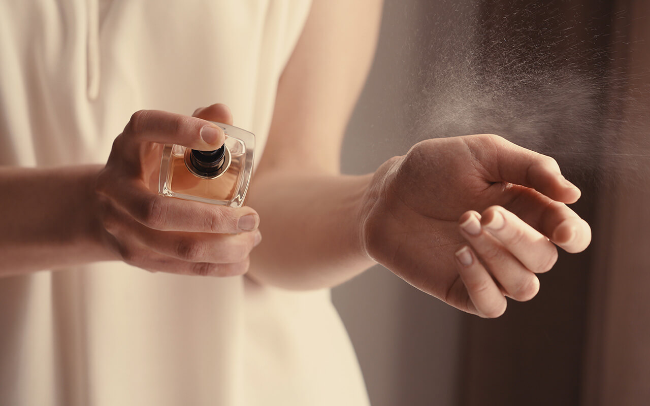 Woman spraying perfume on her wrist