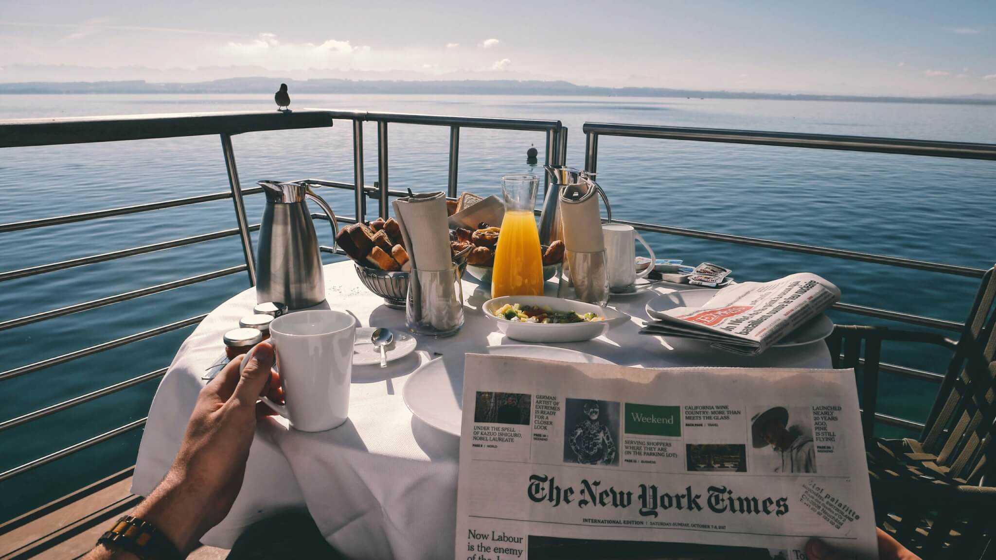 man reading a newspaper on a cruise ship