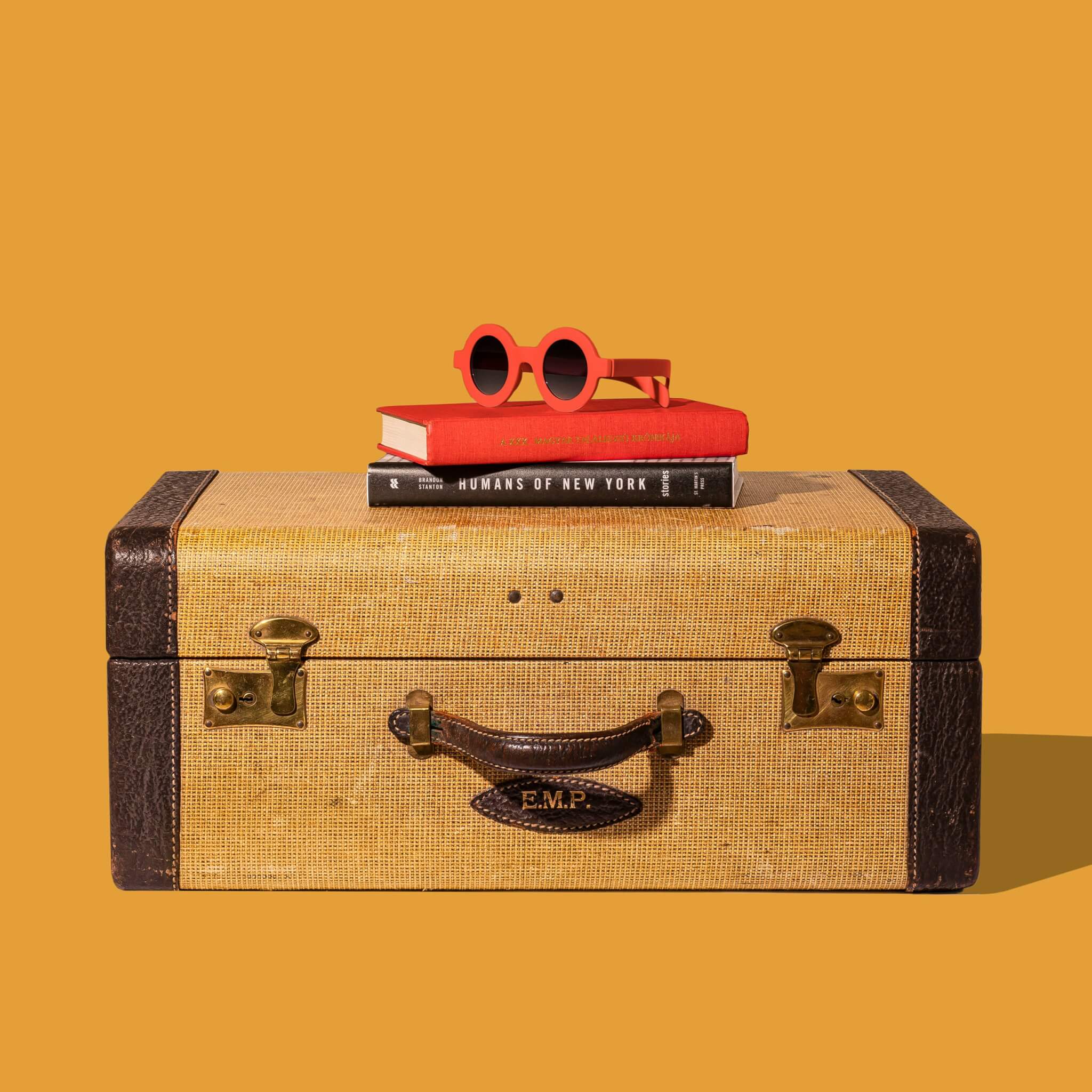 suitcase with sunglasses and books