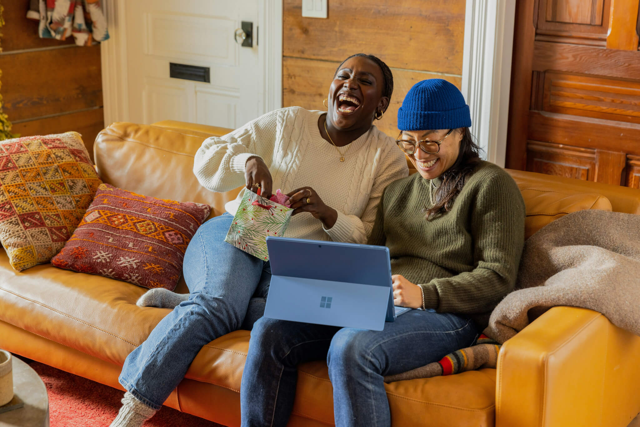 two friends laughing on a couch