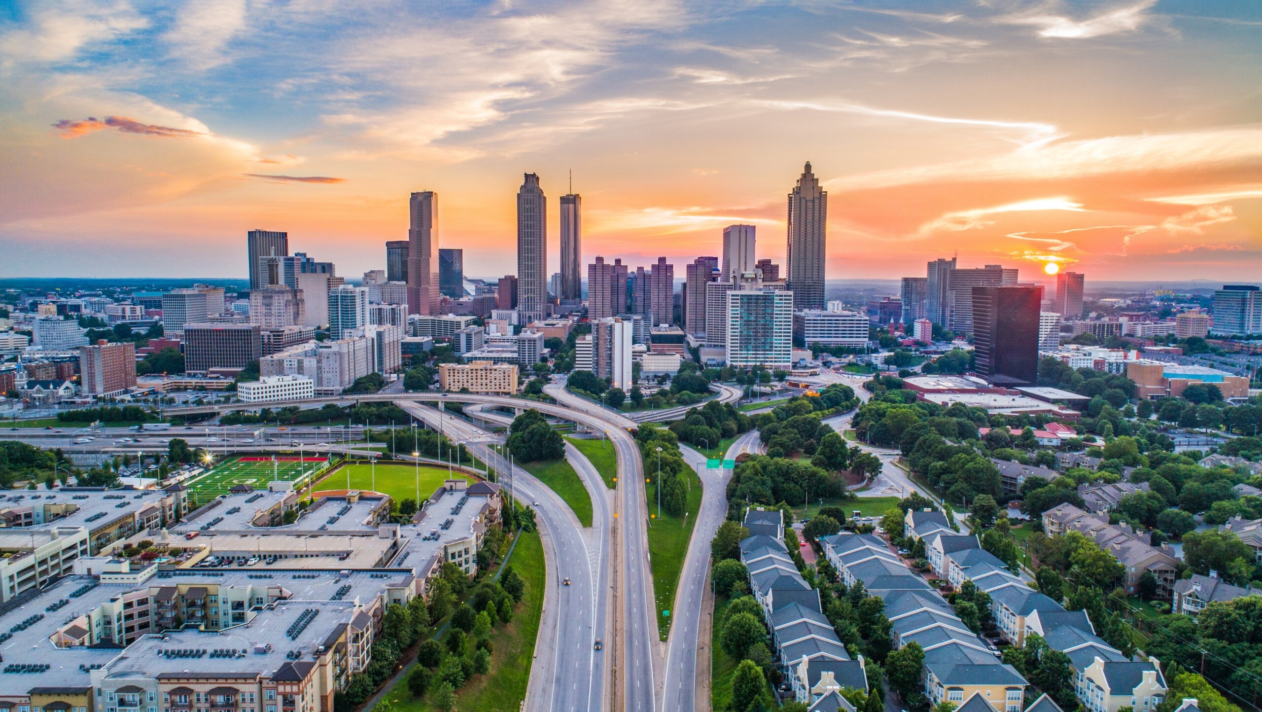 Aerial view of Atlanta, Georgia skyline with skyscrapers and greenery under clear September skies.