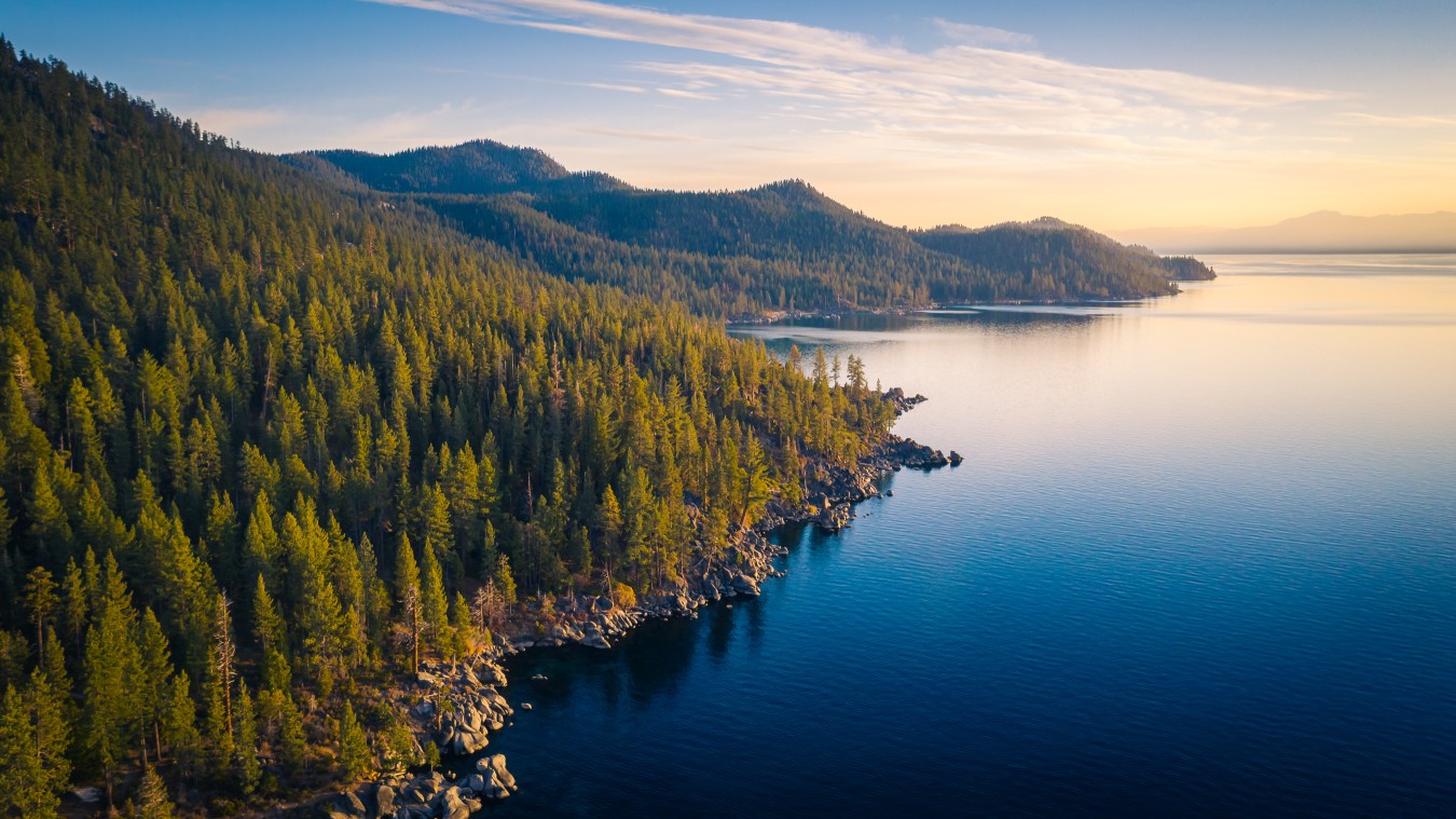 A breathtaking aerial photo of Lake Tahoe’s shoreline, where turquoise-blue waters meet pine-covered mountains and rocky coves. This early fall scene captures the natural beauty of Lake Tahoe in September—ideal for hiking, kayaking, and lakeside escapes.
