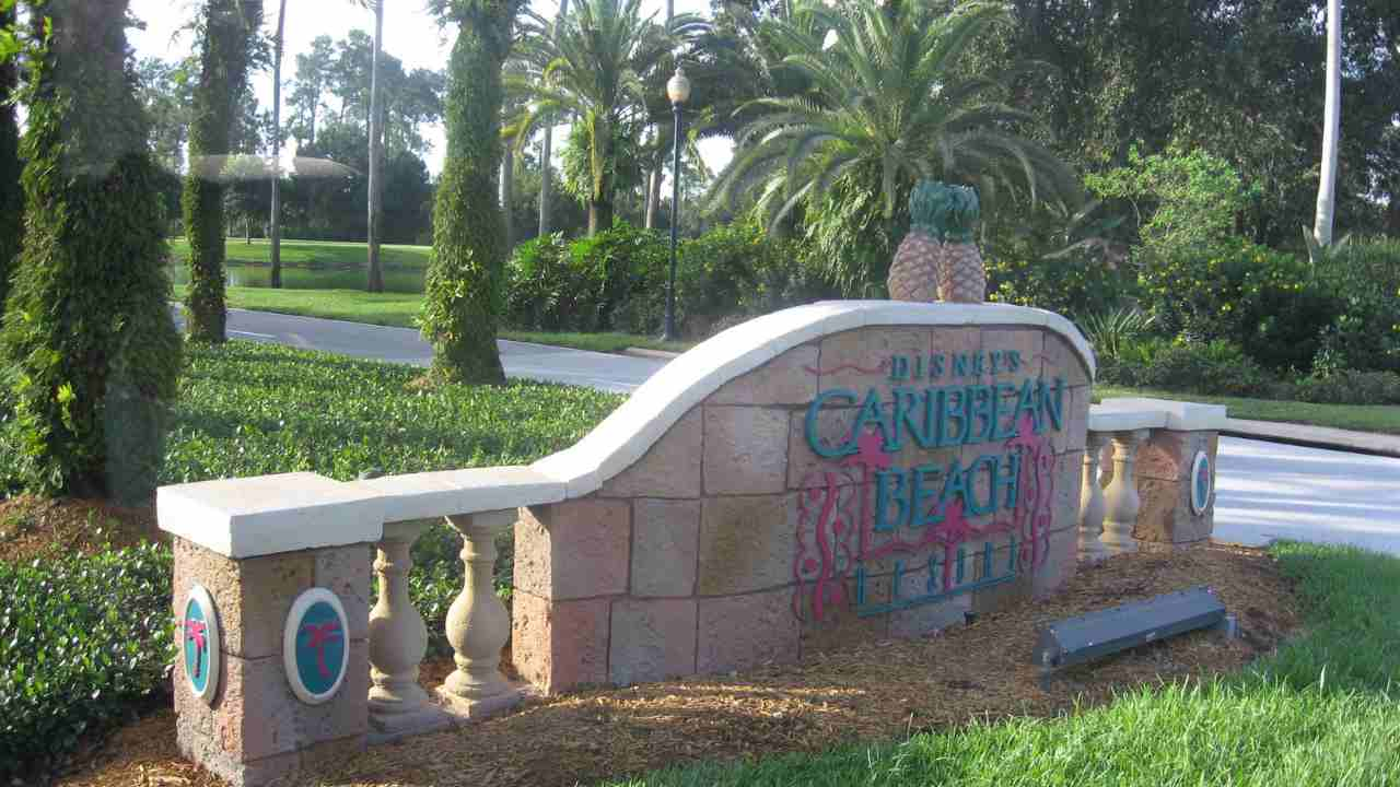 the entrance to a resort with palm trees in the background