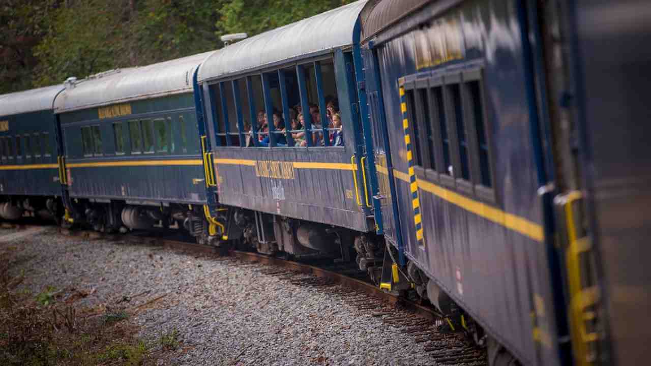 a blue and yellow train traveling down the tracks