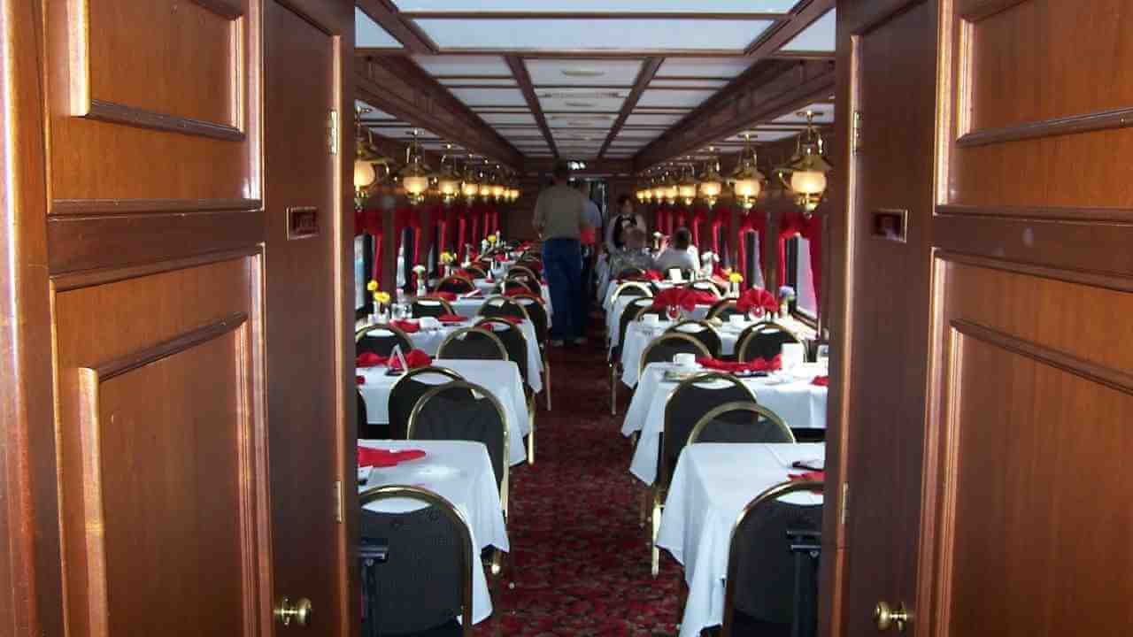 the interior of a train car with many tables and chairs