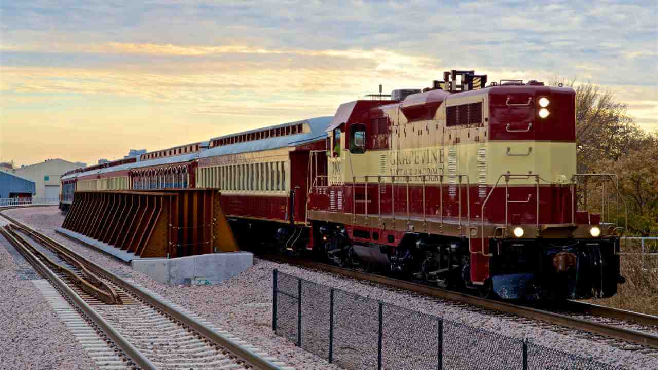 a red and white train traveling down the tracks