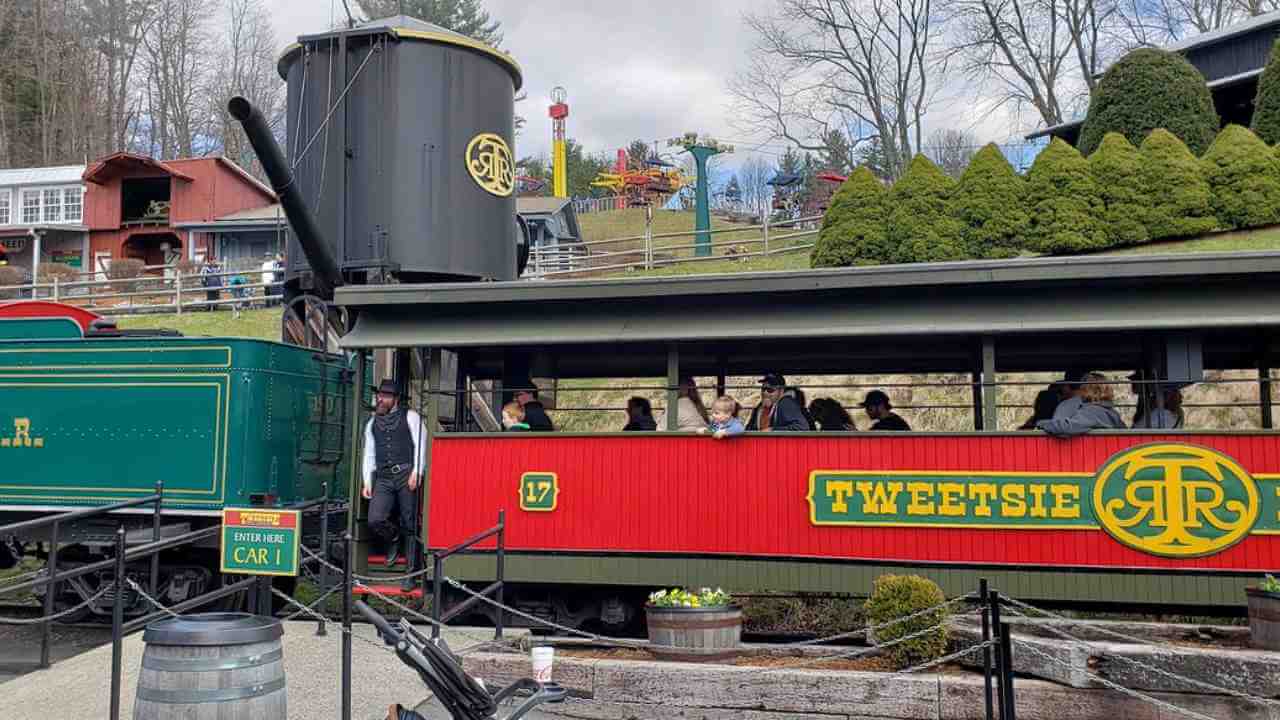 a red and green train with people on it