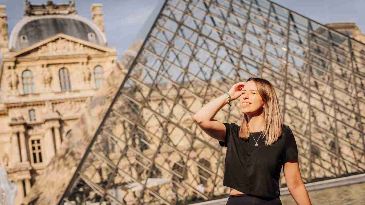 a person posing in front of the louvre museum in paris, france