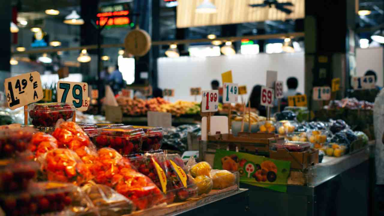 an indoor market with fruit and vegetables on display