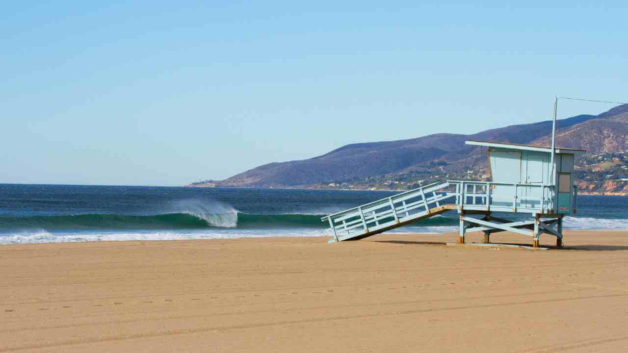 a lifeguard tower sits on the beach next to the ocean