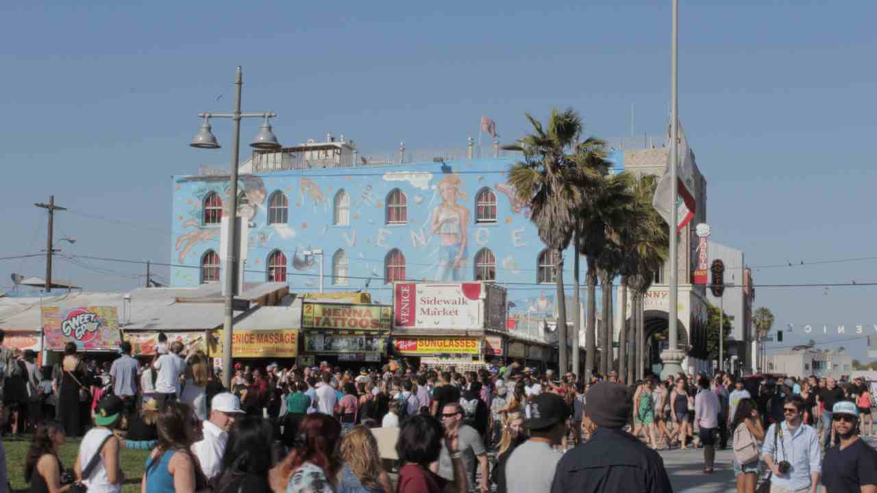 a crowd of people walking down the street in front of a building