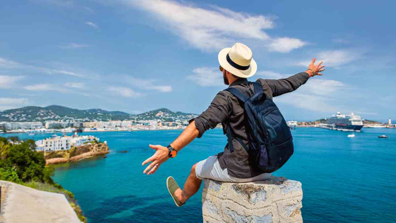 a person sitting on top of a wall with their arms outstretched