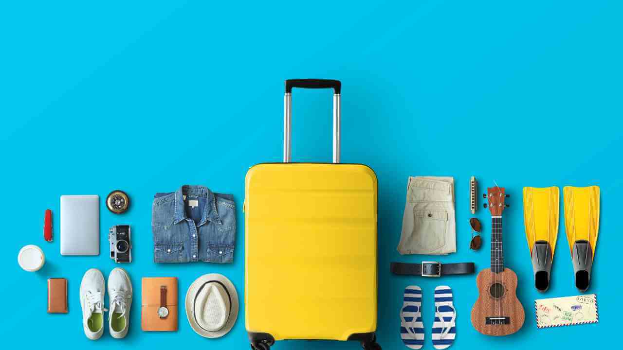 a yellow suitcase surrounded by various items on a blue background