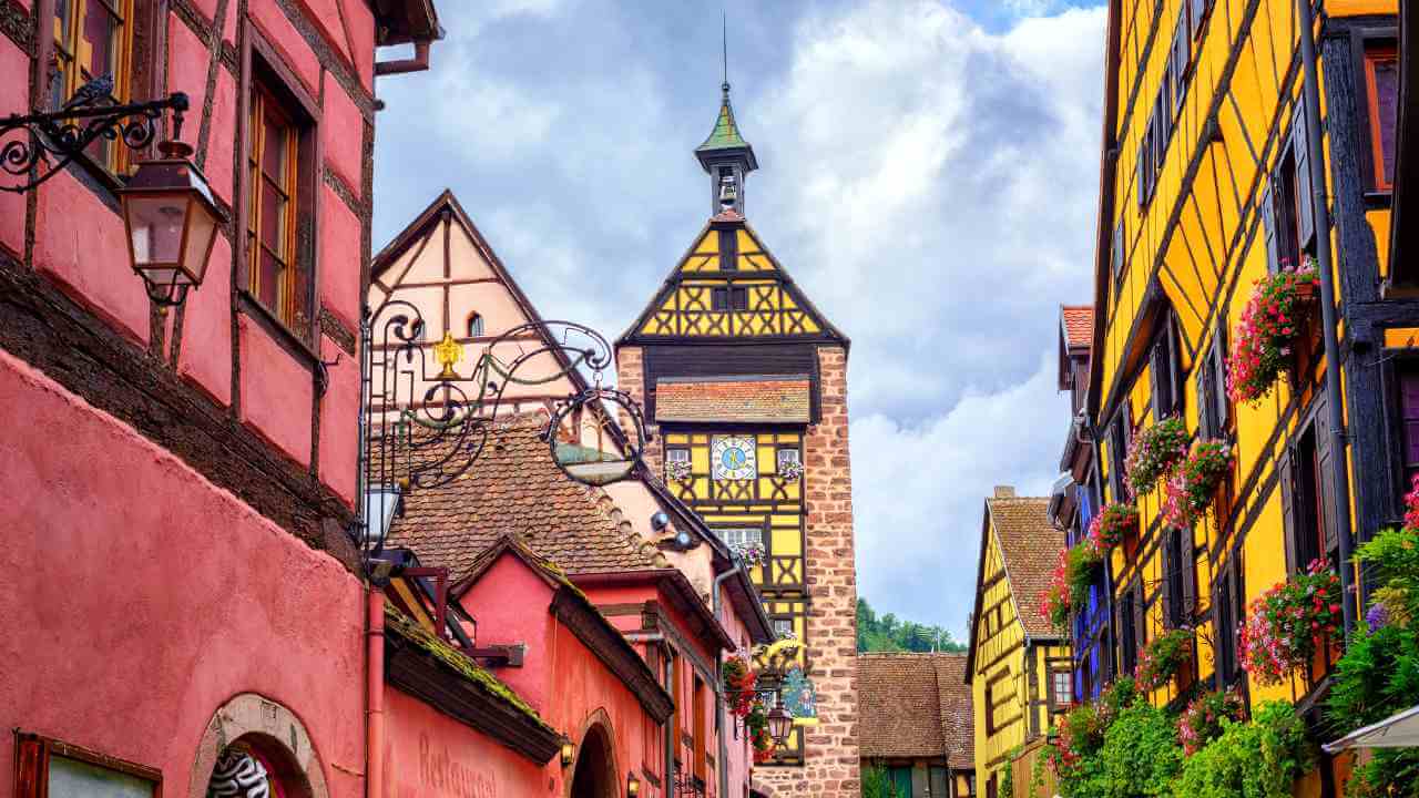 colorful buildings line a narrow street in colmar, alsace, france