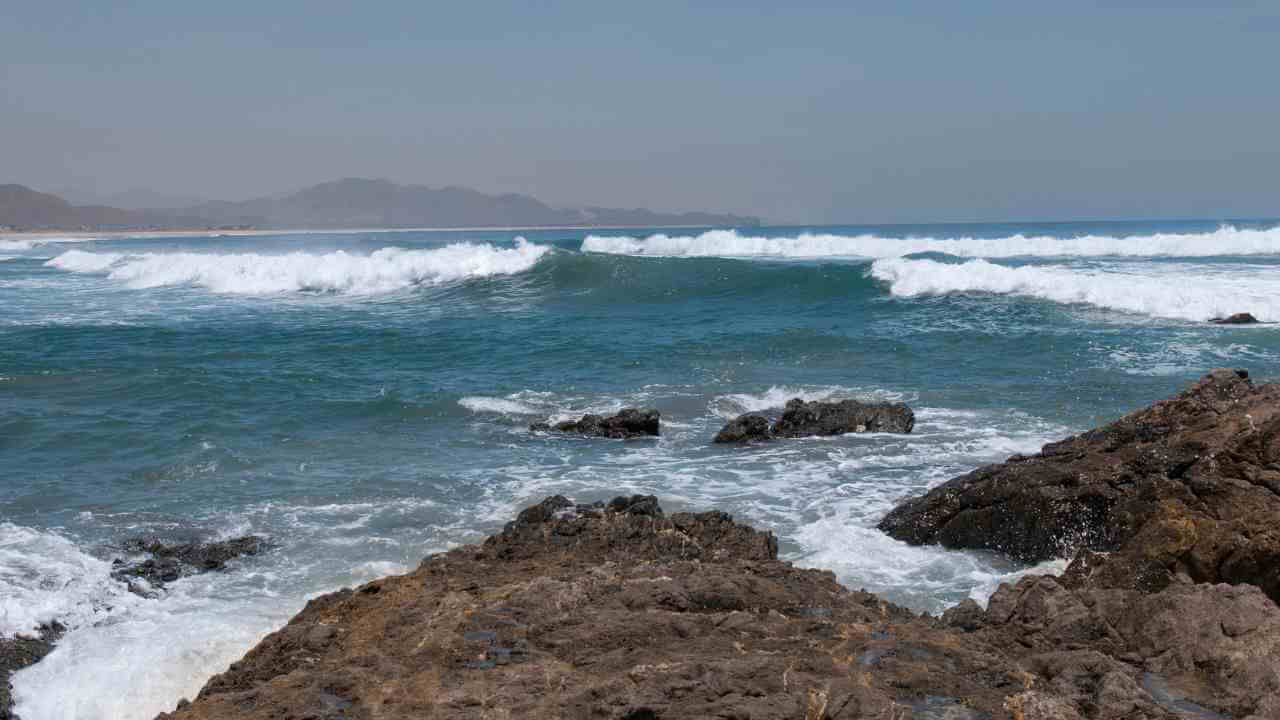 waves crashing on the shore of a rocky beach