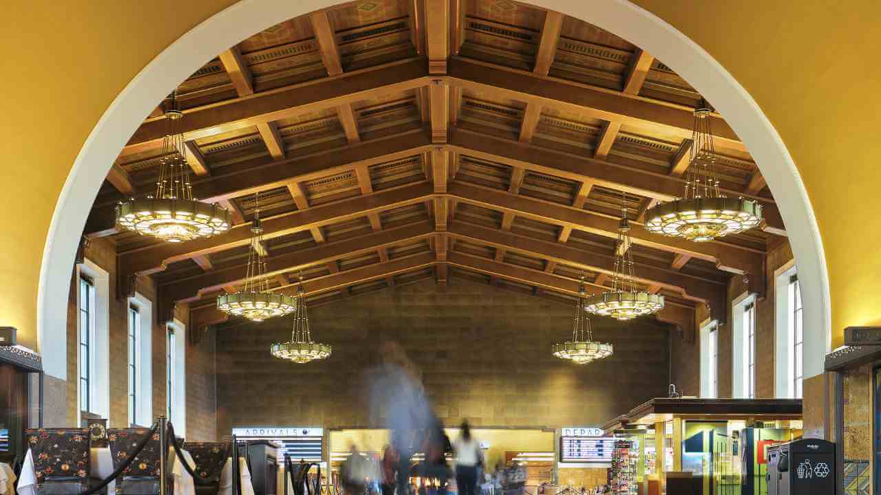 the inside of a train station with people walking around