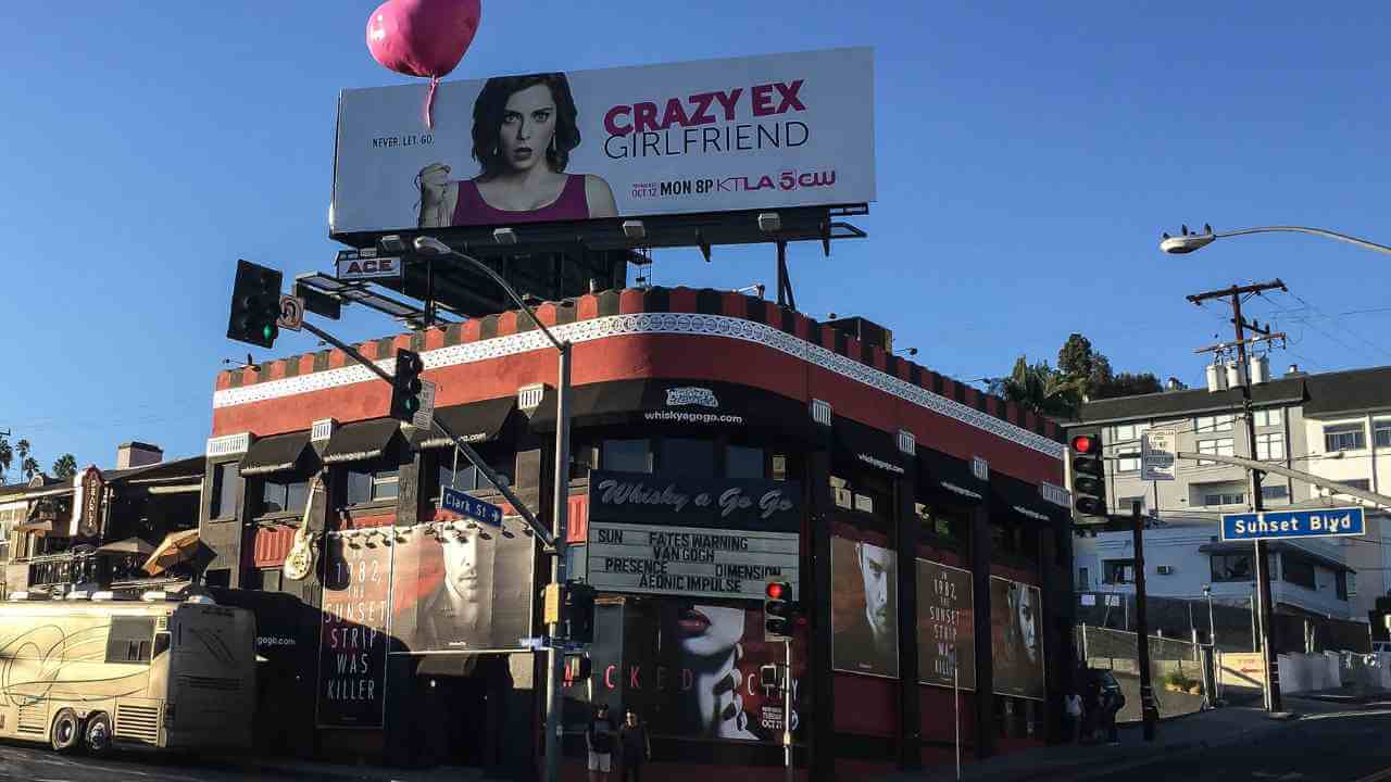 a billboard with a picture of a woman on it in front of a building