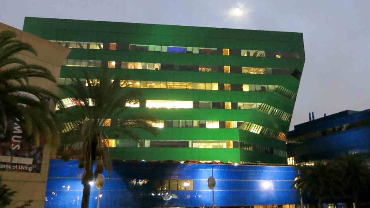 a building with a green and blue facade at night