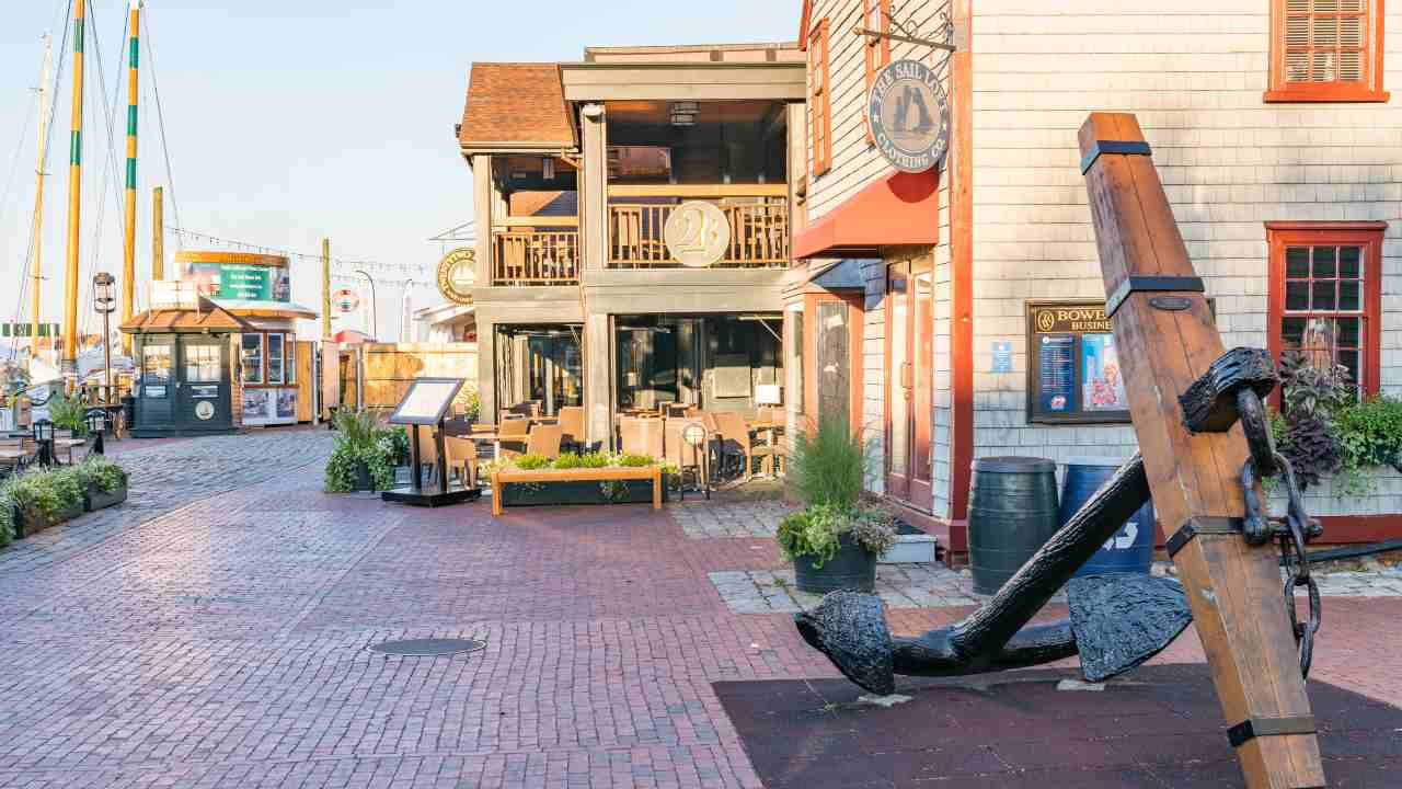 An anchor is sitting on the sidewalk in front of a building