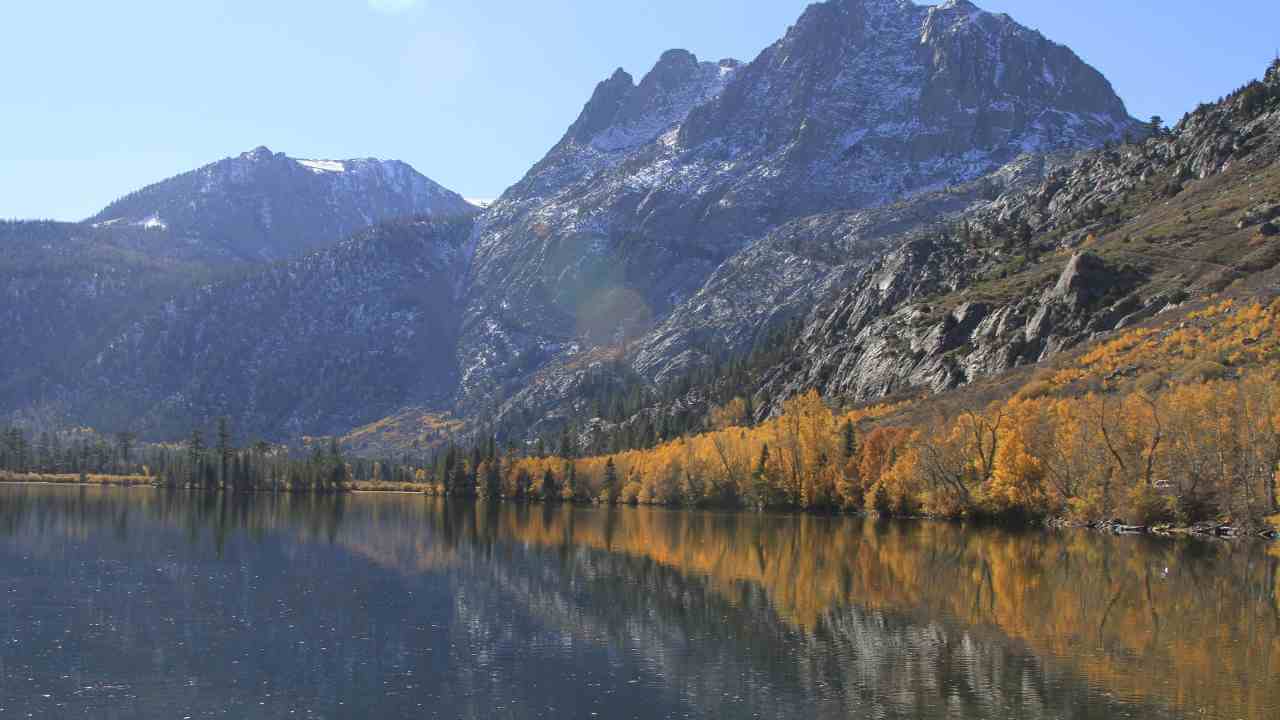 a mountain range is reflected in the water of a lake