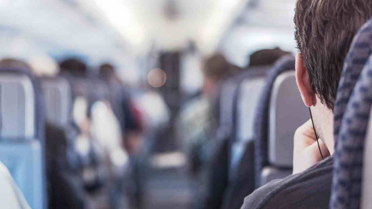 people sitting on an airplane with their backs to the camera