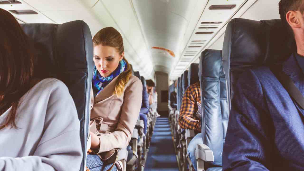 a group of people on an airplane looking at their cell phones