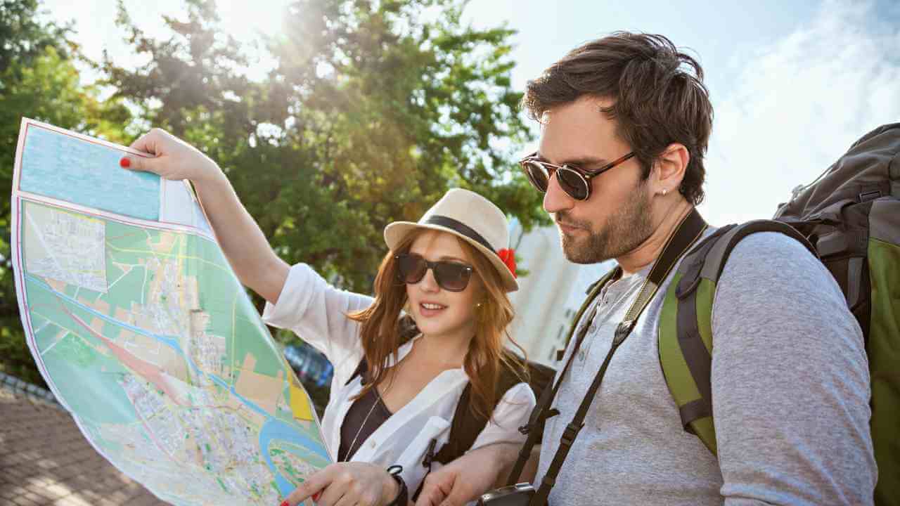 Two people with backpacks looking at a map