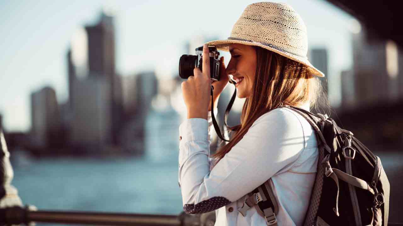 a person in a hat taking a photo with a camera