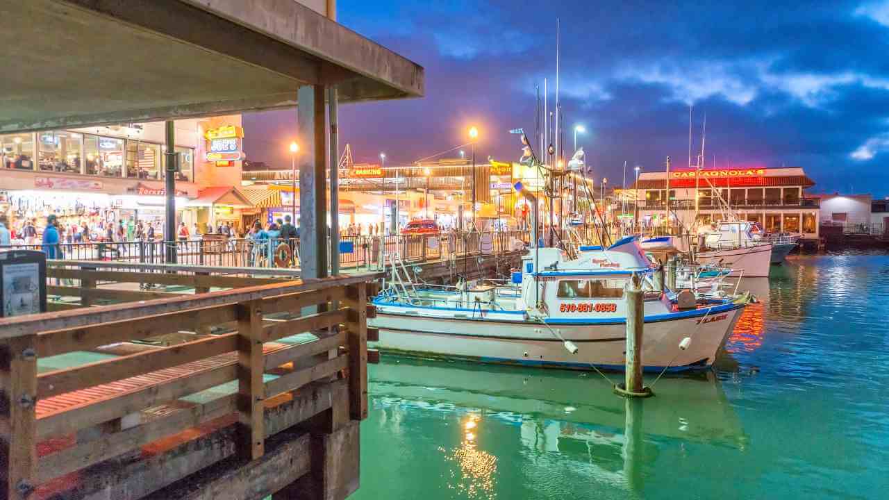 fishing boats are docked at a dock in front of a building