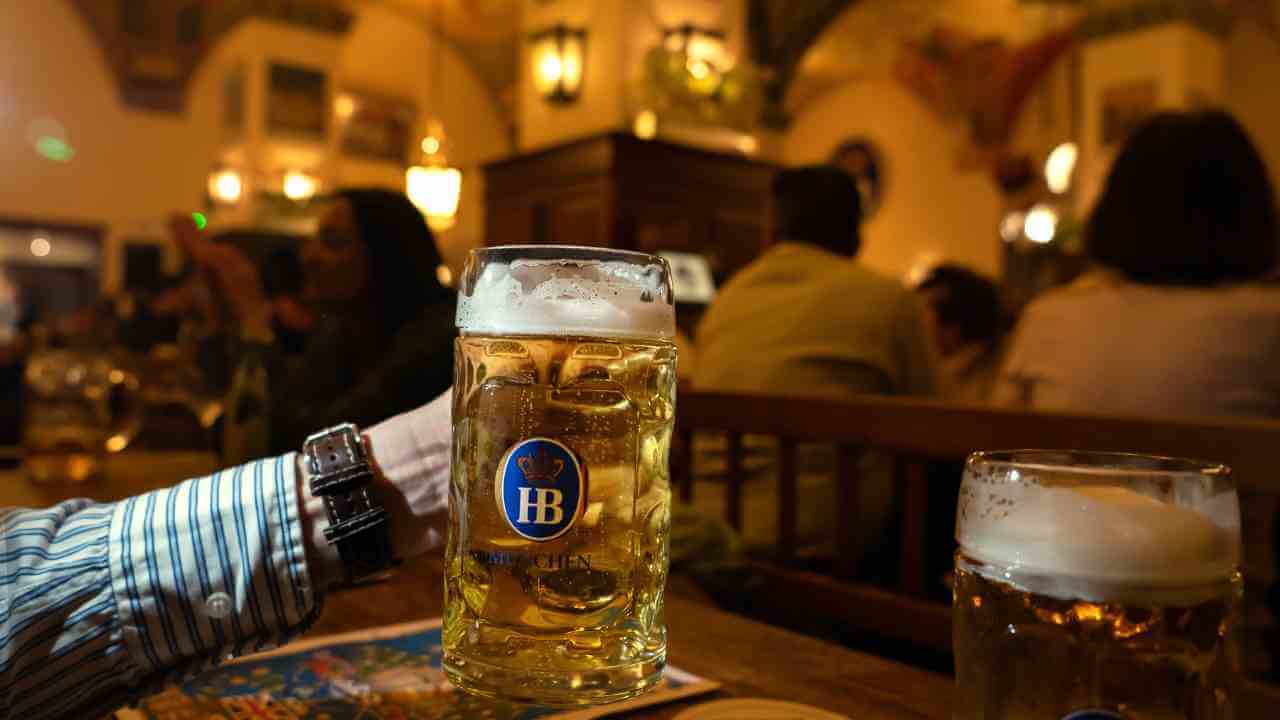 a person holding a glass of beer at a restaurant