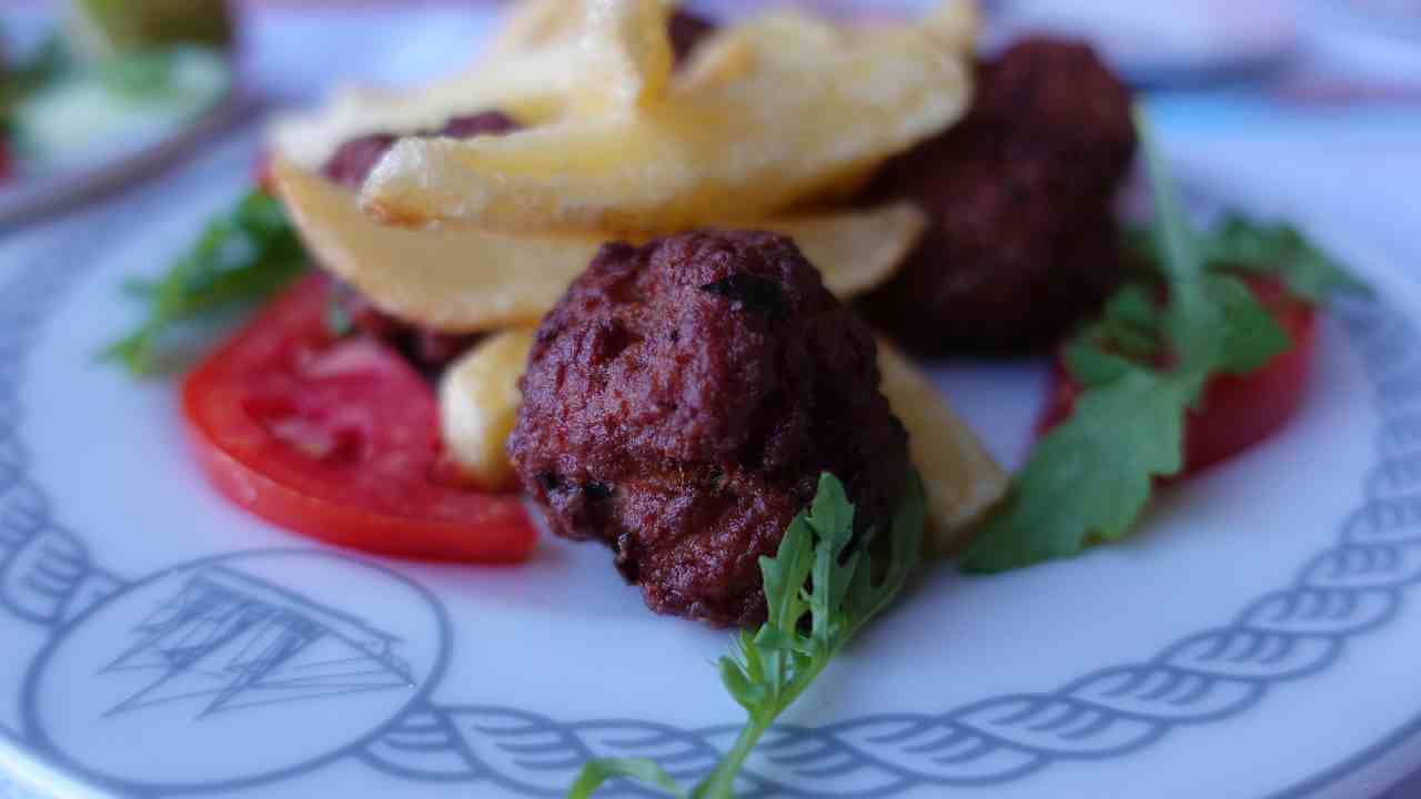 a plate topped with meatballs and french fries