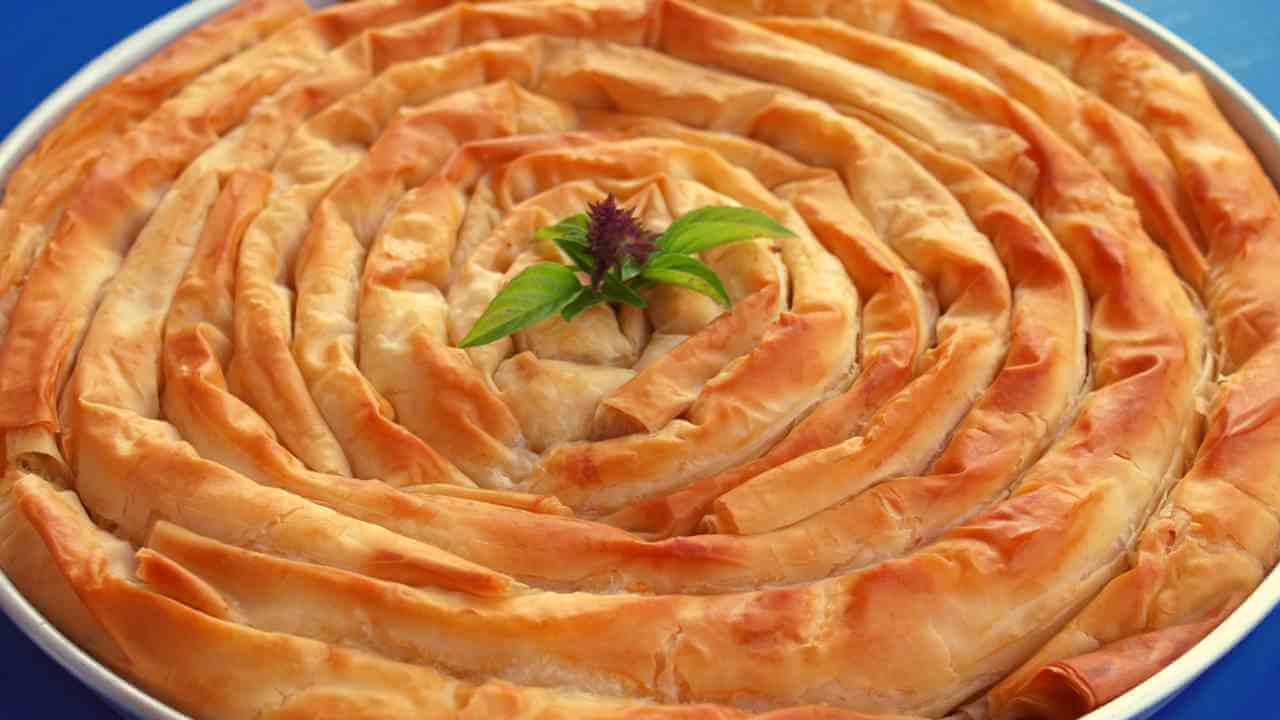 a baklava in a round pan on a blue background