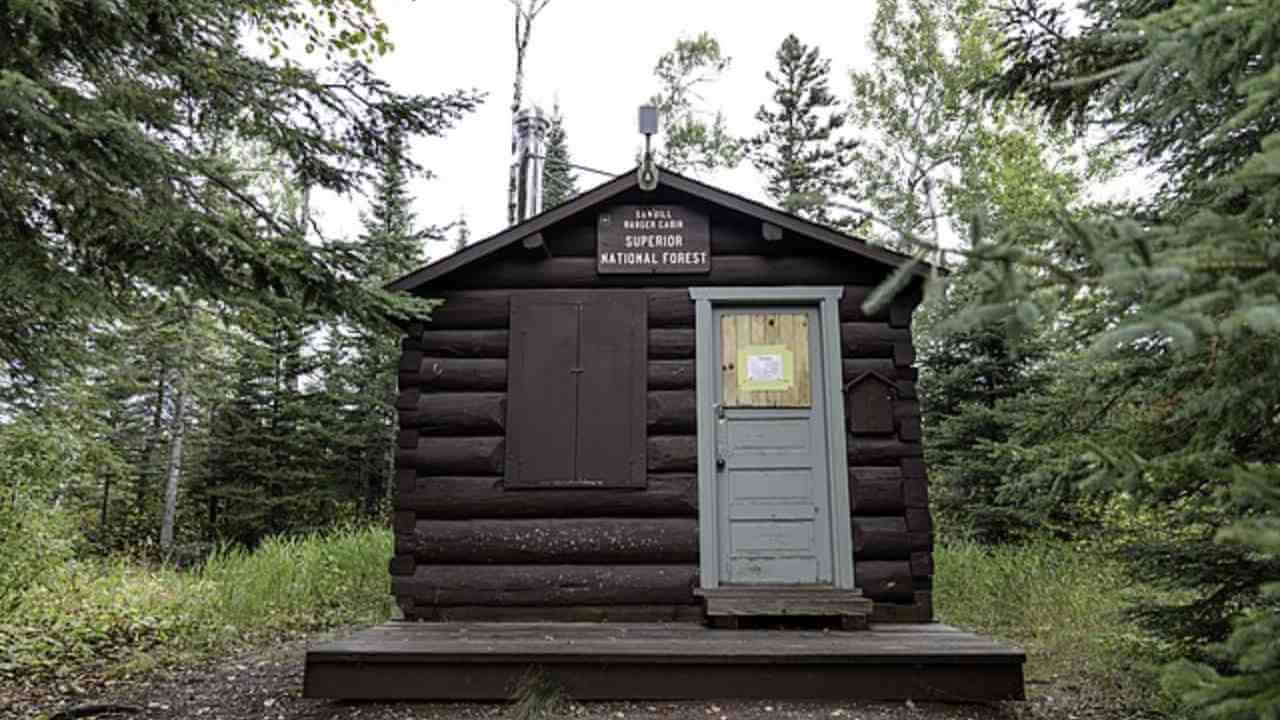 a small log cabin sits in the middle of the woods