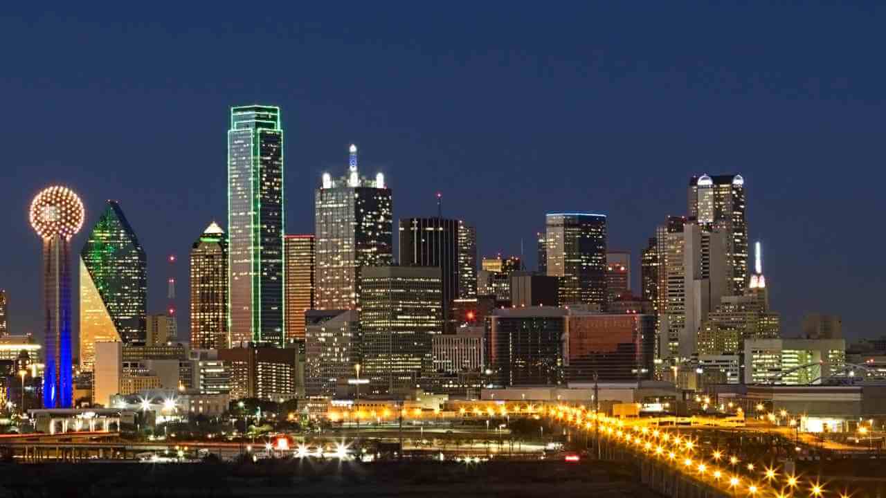 the dallas skyline is lit up at night