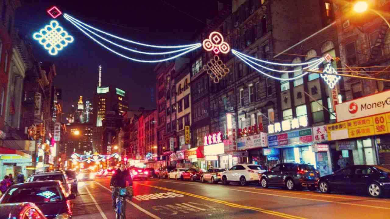 a busy city street at night with lots of cars and people