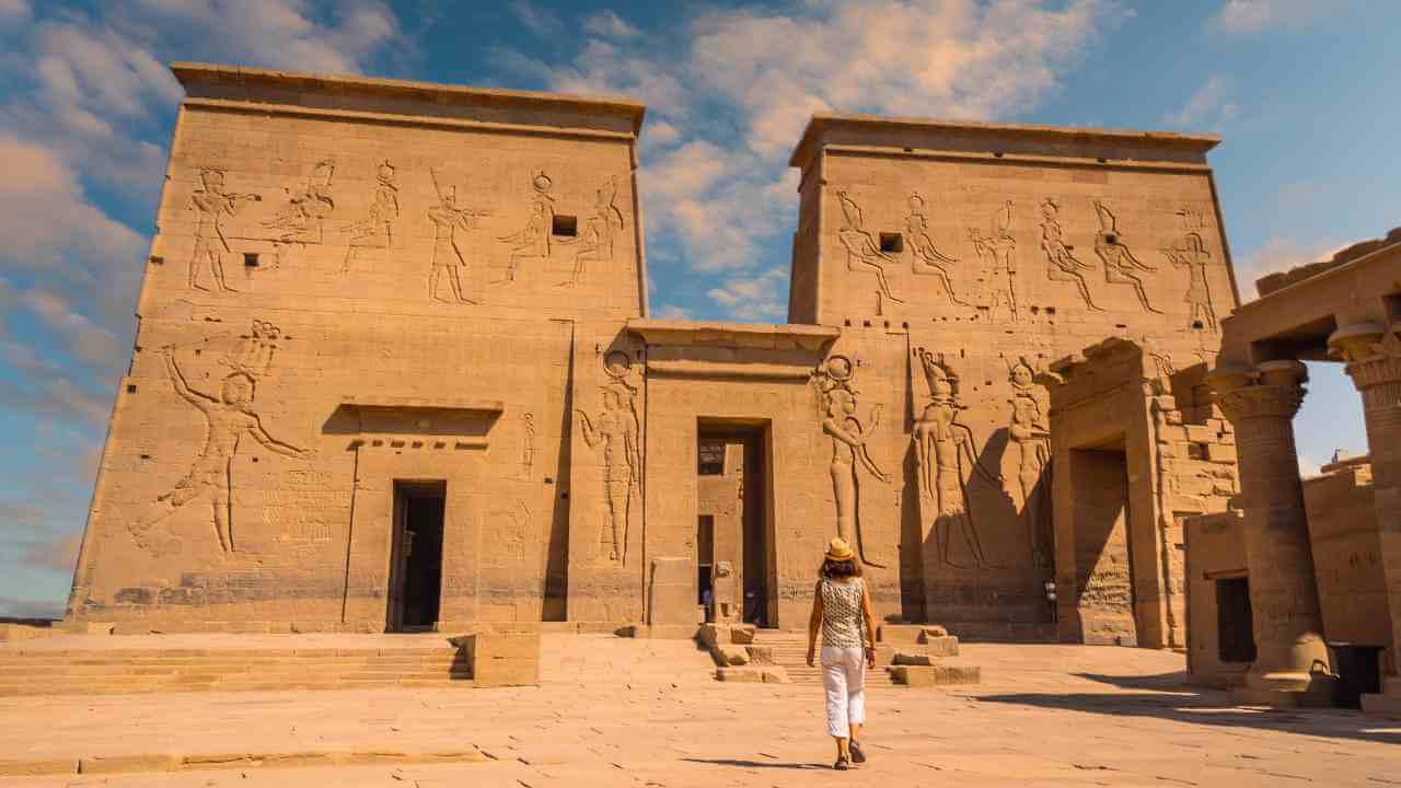 a person is standing in front of an egyptian temple