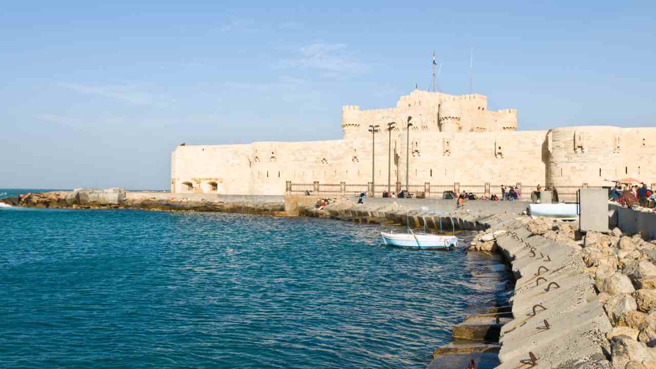 a large stone castle on the shore of a body of water