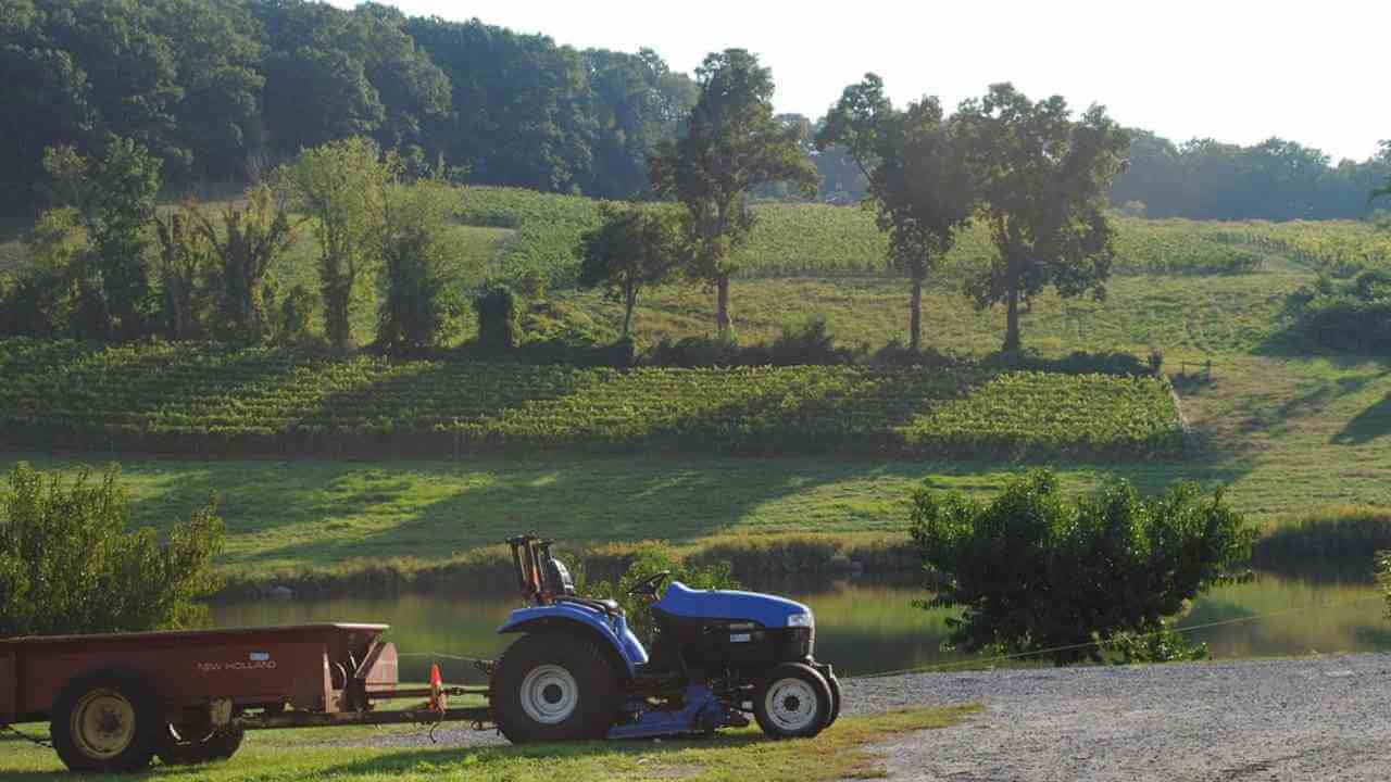 a tractor and trailer parked next to a river