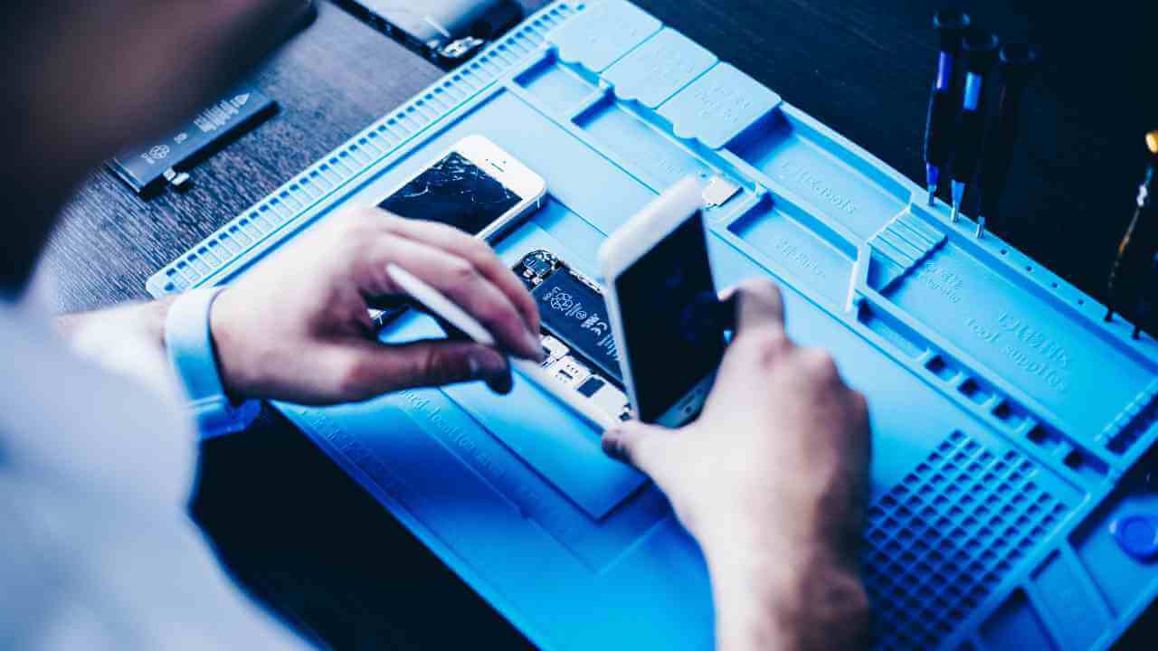 a person is working on a cell phone in front of a blue table