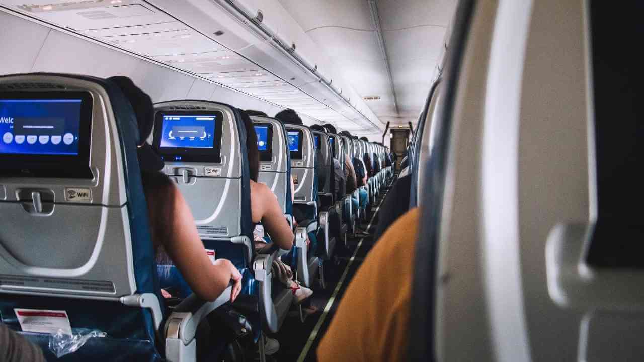 the inside of an airplane with people sitting on the seats