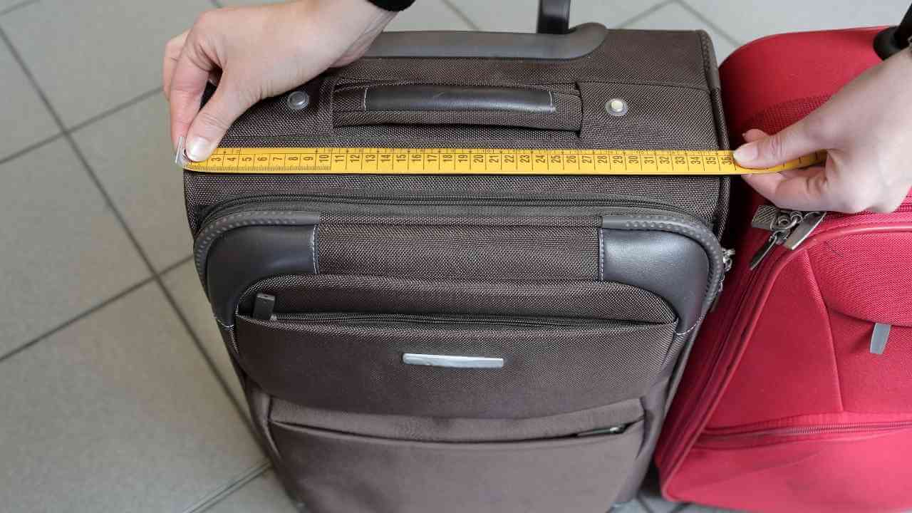 a person is measuring the size of two suitcases