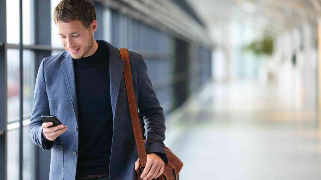 a person in a suit is looking at their cell phone