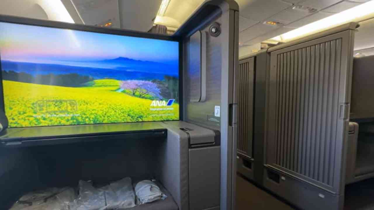 the inside of an airplane with a large tv screen