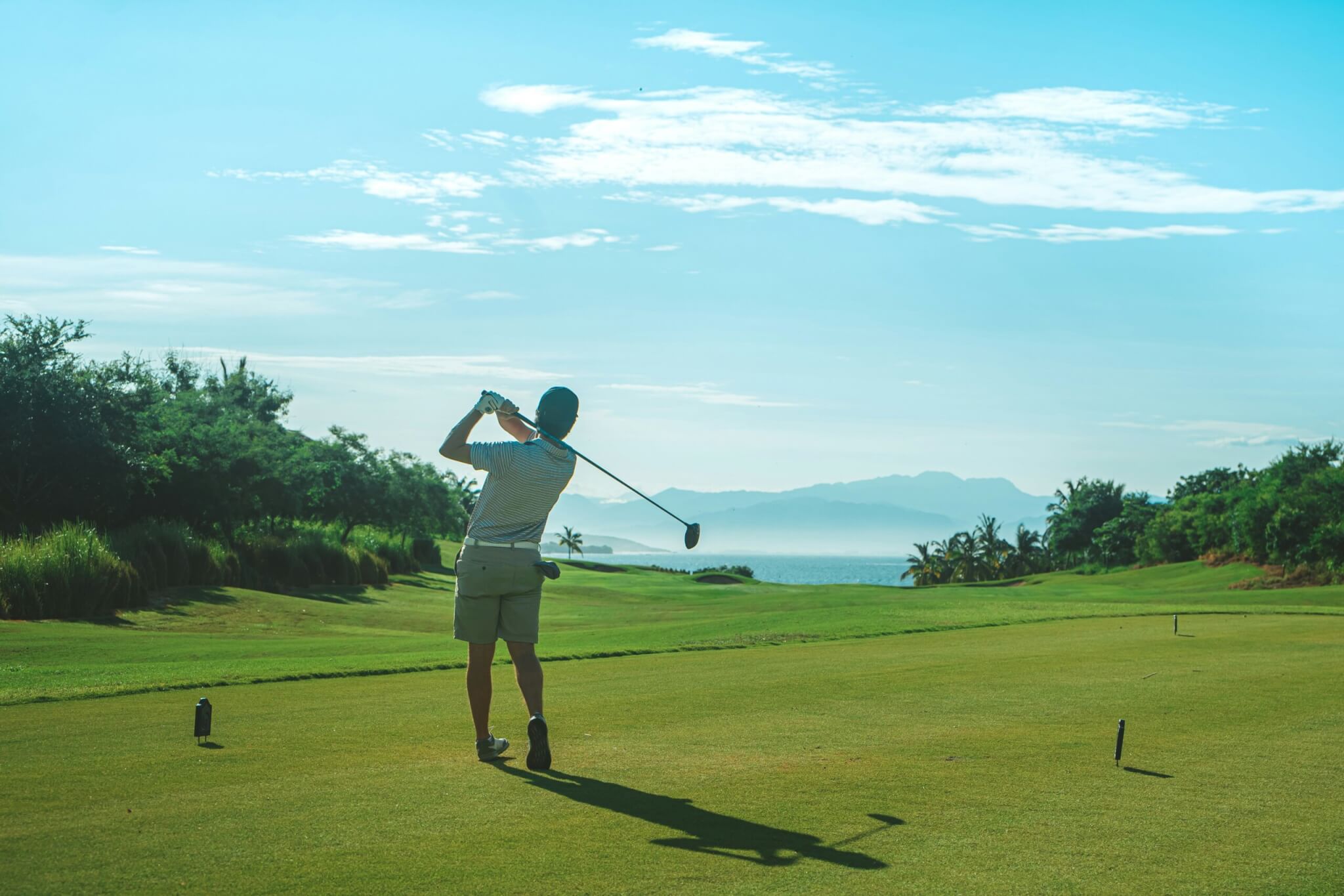 man golfing on beach