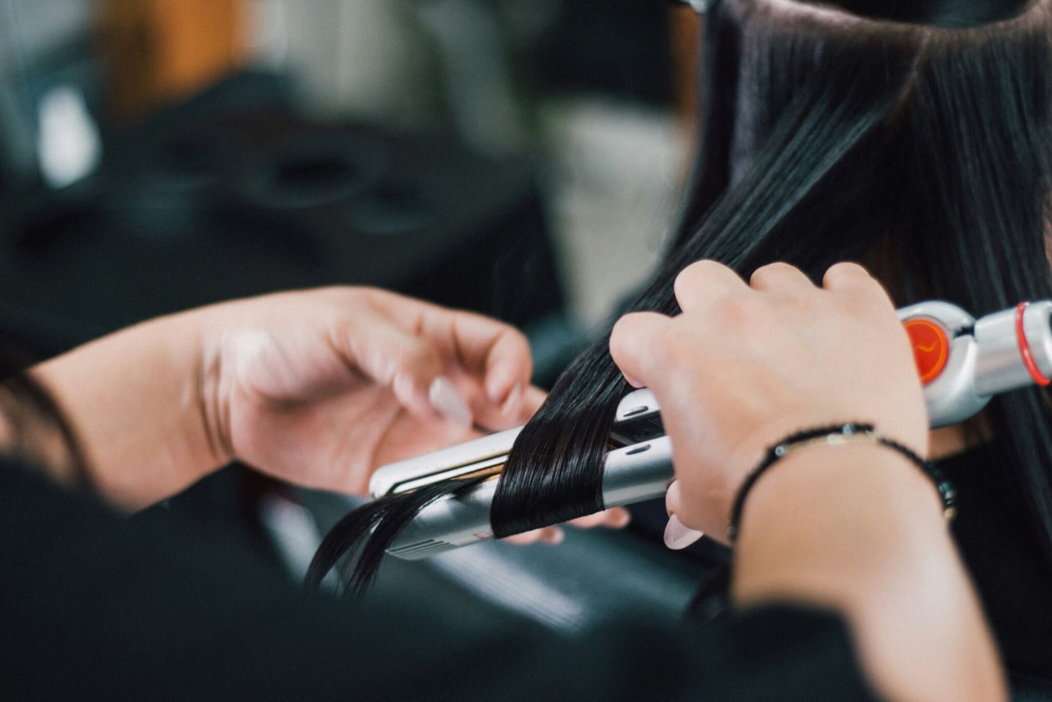 woman using a flat iron on hair