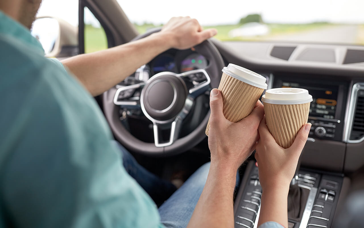 Couple enjoying coffee in the car