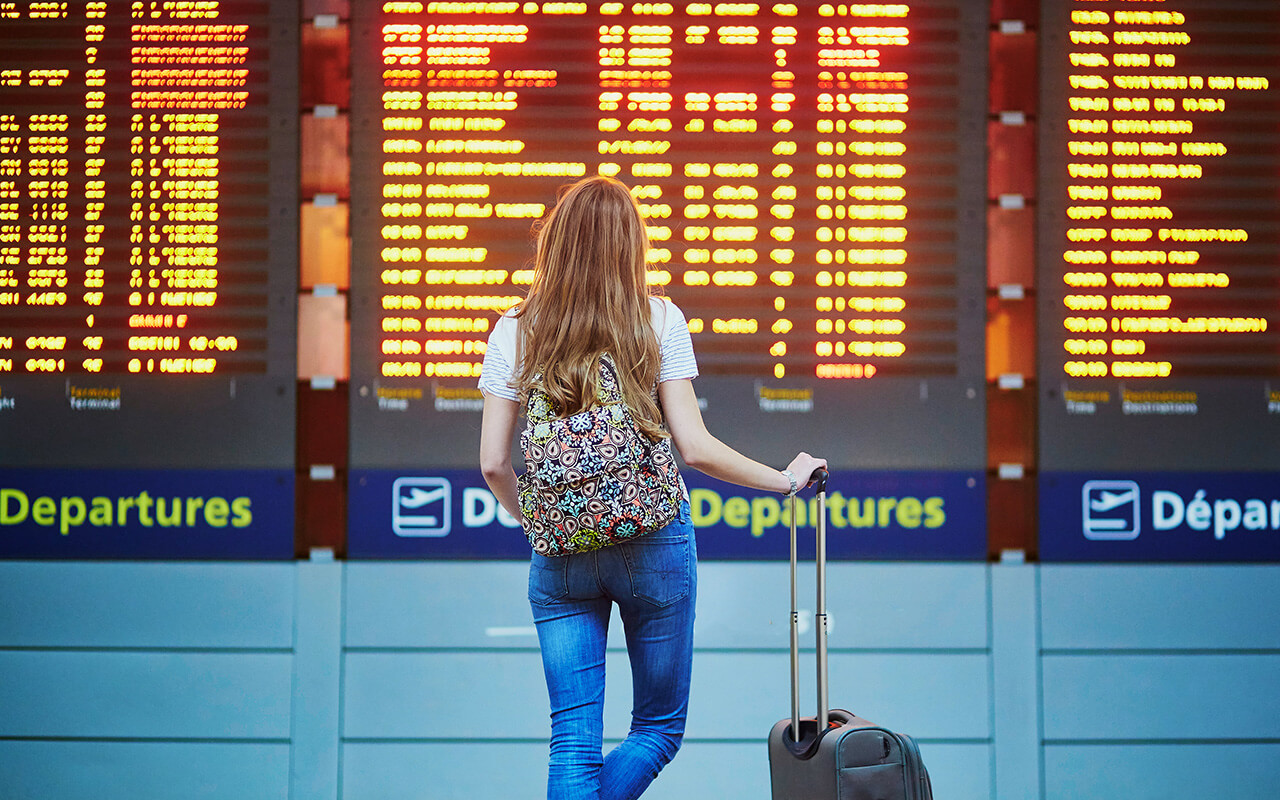 Woman looking at departures board in an airport