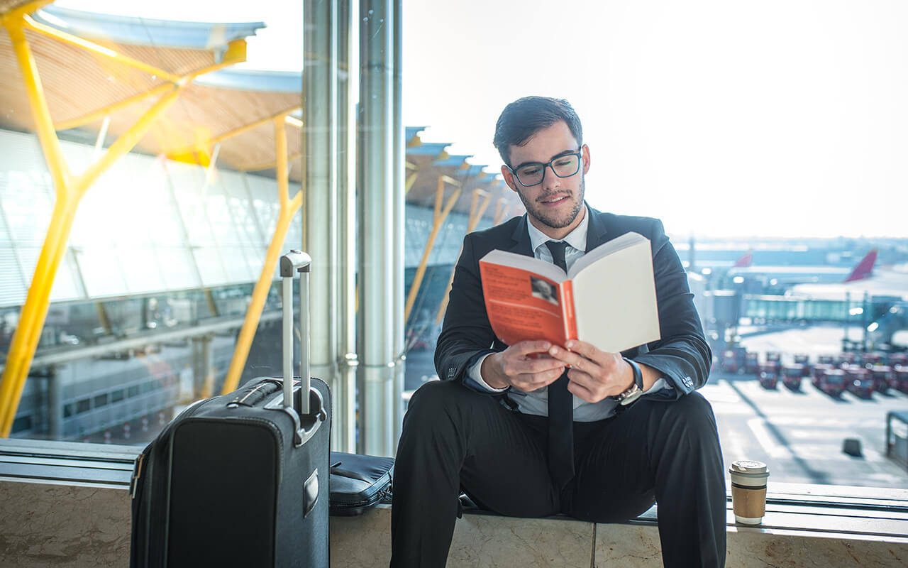 Man reading a book at the airport